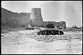 A photograph of the wall of Qatif Castle, featuring one of its towers, taken in 1930 AD.