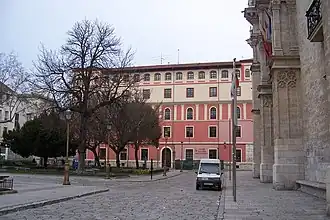 A town square with a palatial house on the background.