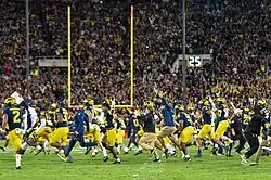 Football players and coaches running onto a football field