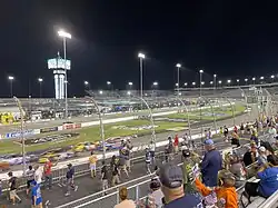 A photo of a restart during a NASCAR Cup Series race at Richmond Raceway. The photo shows the frontstretch and the first two turns.