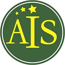 This is a logo of American International School. It is a green emblem with the school's acronym, "AIS", in gold color with three stars from the left-top of the text to the center.