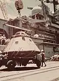 A crane lowers the Apollo CSM-111 capsule at Pearl Harbor from USS New Orleans on 25 July 1975.