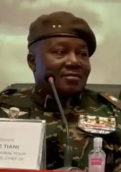 Headshot of a seated Tchiani facing right