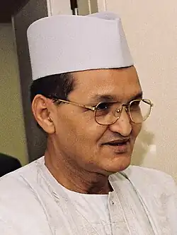 this person. he's wearing white clothing, a white hat, and glasses