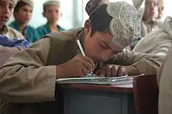 Photo of a boy taking notes at school
