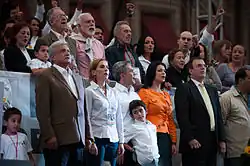 Mancera, at the center of the image, stands with a group in front of a crowd.