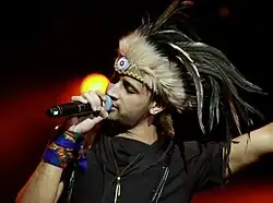 Photograph of a singer while performing and holding a mic