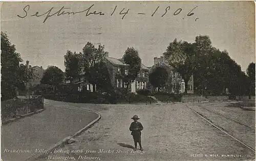 Boy standing in front of the neighborhood on a bridge