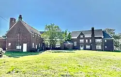1922 Lucy Peters Hall (left) and 1923 Poloke-Bosen Hall in April 2025. Note the façade of Poloke-Bosen is the same as Walter Starr except in reverse order.