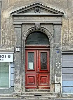 Entrance portal capped by a medallion