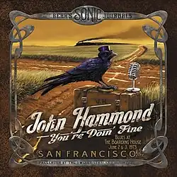 At a country crossroads, a crow is sitting on top of a suitcase. The crow has a microphone and is wearing a top hat.