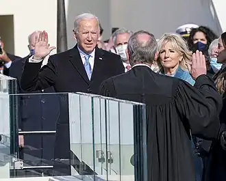 Photo of Biden raising his right hand, with his left hand placed on a thick Bible