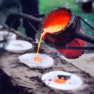 Liquid bronze at 1200&nbsp;°C is poured into the dried and empty casting mould