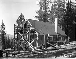 Photo of men working to construct a cabin