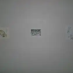 Three small pictures on a white wall.