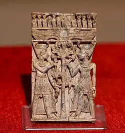 Carved ivory panel showing young Egyptian pharaohs flanking a lotus stem and flowers. From Nimrud, Iraq. Iraq Museum, Baghdad.