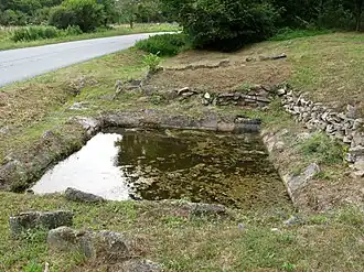The abandoned washing pool, on the north side of the D15 road