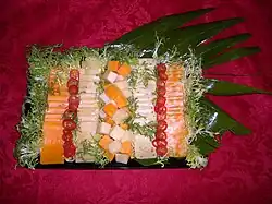 Cheese tray garnished with red pepper rings and chicory