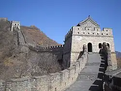 A stone wall going uphill with towers spaced along it