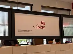 A picture of a logo for Chick-fil-A play with a QR code to download it at a restaurant