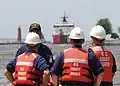 Coast Guardsmen await the arrival of the USCGC Mackinaw