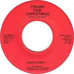 The label of Crabs for Christmas. On the top side, it says "Crabs for Christmas (David DeBoy)", "Outrageous Records, Inc. Time 3:31. 21217 A. Vocal." on the left, "Published by Old Bay Publishing ASCAP, copyright 1981" on the right, and "David DeBoy. Produced by J. Friedman and B. Hardesty. Engineer Victor Giordano." on the bottom.