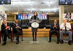 Angela Alsobrooks standing at a podium with four people next to her.