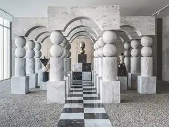 Three halls of portals made of black and white marble displays an sculpture each at their ends