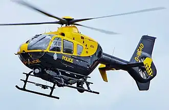 Close up of blue and yellow helicopter hovering