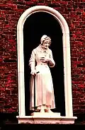 Statue of an elderly woman at the almhouses. The almshouses have been open continuously since 1676.