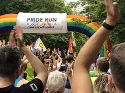 inflatable rainbow colored finish line gate for long distance runners with people cheering
