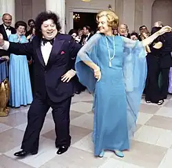 Ford dancing with comedian Marty Allen in the Entrance Hall of the White House of the White House during a September 21, 1976 state dinner in honor Liberian President William Tolbert