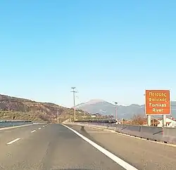Road sign with the inscription "Foinikas River" (On the Olympia Odos highway bridge over the river)