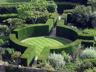a circular enclosure of green hedging surrounding a lawn