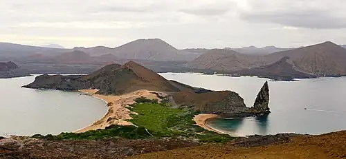 Image 17Pinnacle Rock on Bartolomé Island, with Santiago in the background and a ferry on the right for scale (from Galápagos Islands)