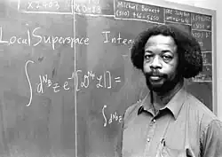 S. James Gates lectures from a chalkboard.