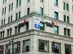 Global Montreal signs on the lower floors of a limestone-faced office building.