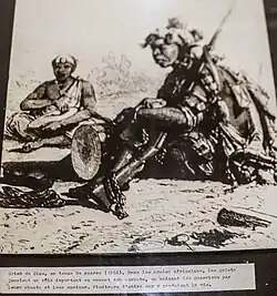 Photo of a griot in war dress (1866).