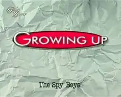 An image of a white crumpled paper. The series title is displayed on the center of the image. The text "Spy Boys!" are written in the lower center of the image. The text "Tunay na Buhay" is seen in the upper left side of the image.