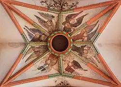 Gothic Holy Ghost hole framed by 15th-century frescos at Church of the Holy Spirit, Heidelberg.