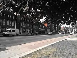 group of buildings alongside a large street with many cars