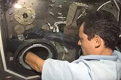 Over the shoulder view of European Space Agency (ESA) Astronaut Pedro Duque as he works at the Microgravity Science Glovebox for the Cervantes mission experiment PromISS 2 in the Destiny U.S. Laboratory during joint operations with the Expedition 7 and Expedition 8 crews.