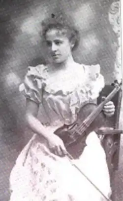 A young white woman holding a violin