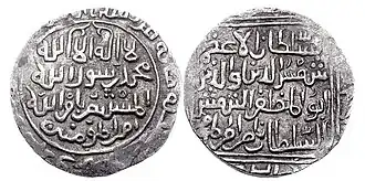 A photograph of the two sides of a coin with a white background. The coins are grey-black in color and have white-colored Perso-Arabic calligraphy on them