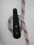 A jam cleat. The rope is free to run around the lower part of the cleat (below the screws). The upper part is tapered so that the space between the cleat and the boat gets smaller closer to the screws, causing the rope to jam in the cleat when it is pulled downward.