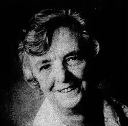 Jane Madders smiles in a black-and-white photo. She has short, greying hair done up in a perm hairstyle.