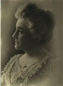 B&W portrait photo of a middle-aged white woman with her hair in an up-do, wearing a pale-colored blouse.