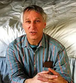 John Curl with a bed in the background