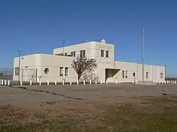 One-story building with two-story central section; rounded corners