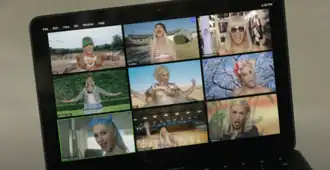 A still of the music video for Gwen Stefani's 2020 single "Let Me Reintroduce Myself", displaying a laptop broadcasting a Zoom call with nine different versions of the singer.